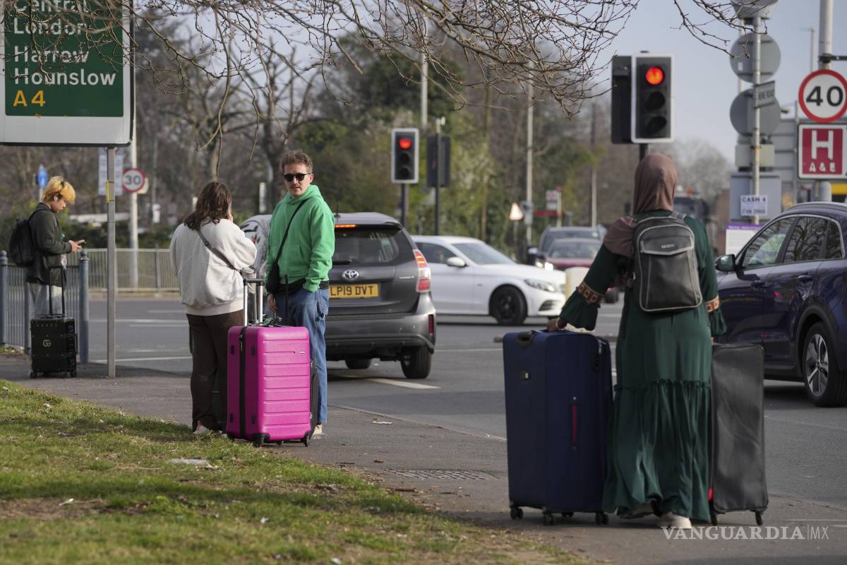 $!Pasajeros en una carretera cercana después de que el Aeropuerto Heathrow de Gran Bretaña cerrara afectando los vuelos de cientos de miles de pasajeros.