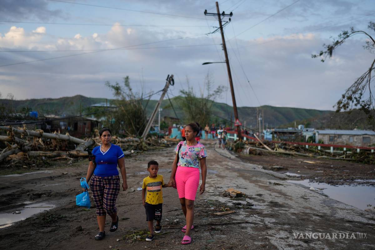 $!Residentes caminan tras el paso del huracán Melissa en El Cobre, Cuba.