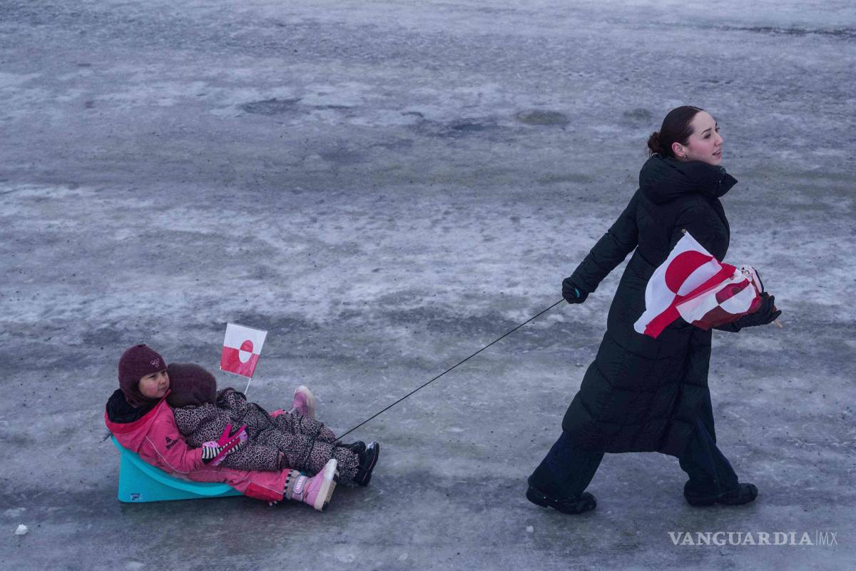 $!Una mujer tira de sus hijos en un trineo durante una protesta contra la política de Donald Trump hacia Groenlandia frente al consulado estadounidense en Nuuk.