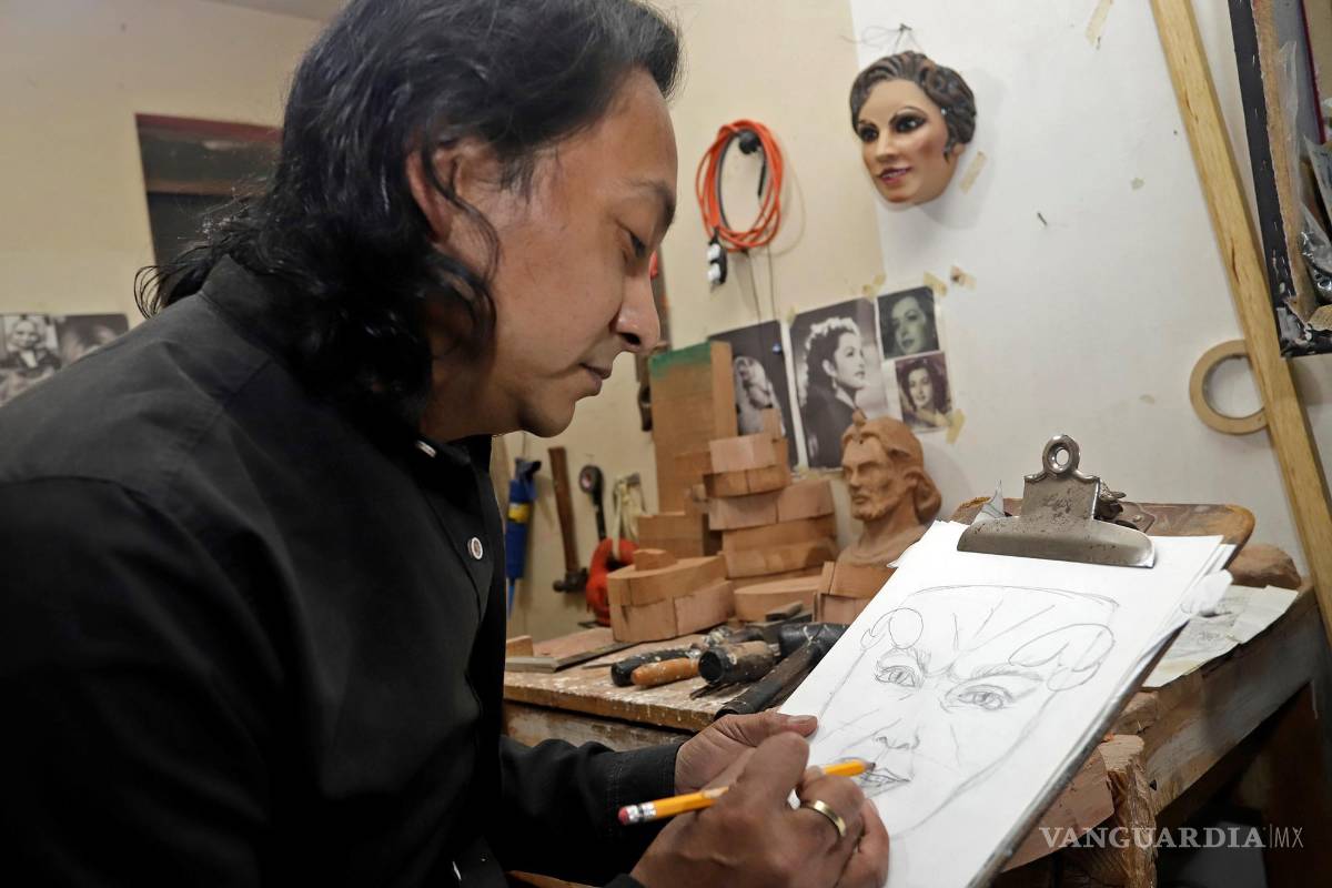 $!El escultor Adrián Becerra mientras trabaja en su taller de máscaras talladas en madera artesanal, en la ciudad de Puebla (México). EFE/ Hilda Ríos