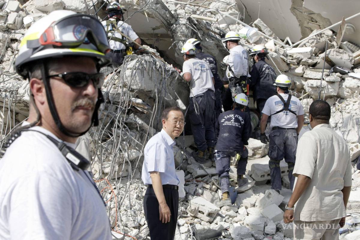 $!El secretario general de la ONU, Ban Ki-moon, centro, visita las oficinas de la ONU en Haití, destruidas por un terremoto, en su visita a Puerto Príncipe, el 17 de enero de 2010.
