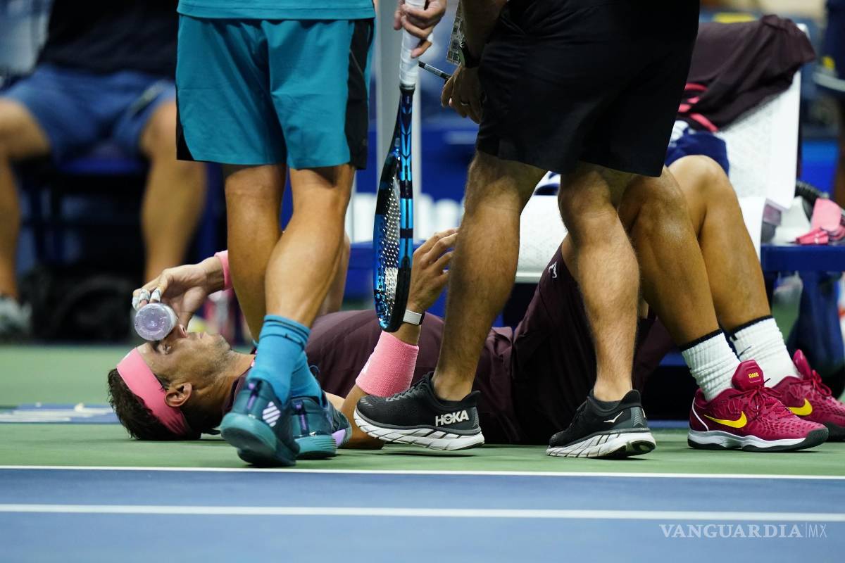 $!Rafael Nadal sostiene una botella en su rostro al recibir tratamiento durante el partido contra Fabio Fognini en la segunda ronda del US Open.