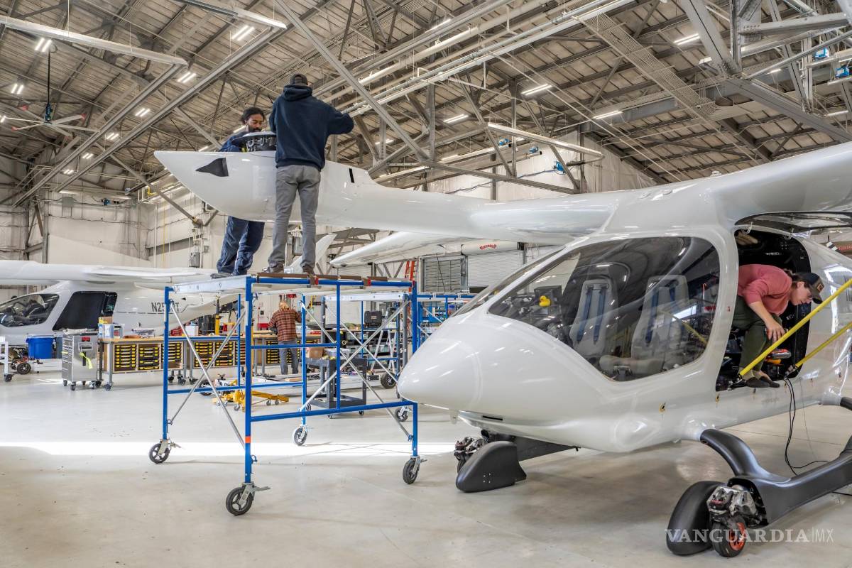 $!Empleados de Beta Technologies trabajan en dos aviones eléctricos en unas instalaciones en Plattsburgh, Nueva York.