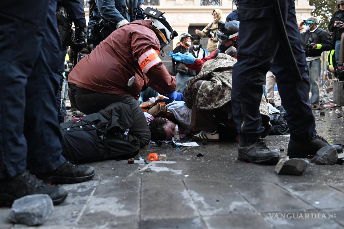 $!Un fotógrafo yace herido durante una manifestación contra el aumento del costo de vida, que se suma a las reivindicaciones de los estudiantes, en París.