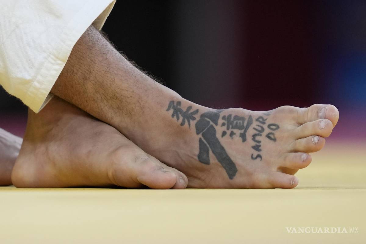 $!Un tatuaje con los personajes de “Judo” se puede ver en el pie de Peter Paltchik de Israel, a la izquierda, durante su ronda de cuartos de final masculina de -100 kg | (AP Photo / Vincent Thian)