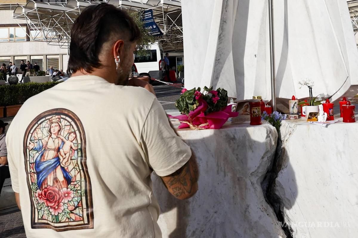 $!Un hombre reza cerca de la estatua del papa Juan Pablo II frente al Hospital Universitario Agostino Gemelli, donde está hospitalizado el papa León XIV.