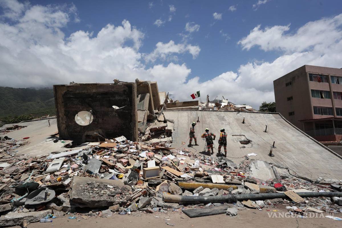 $!Integrantes del equipo de rescate de México realizan labores de búsqueda en un edificio afectado por los terremotos en La Guaira, Venezuela.