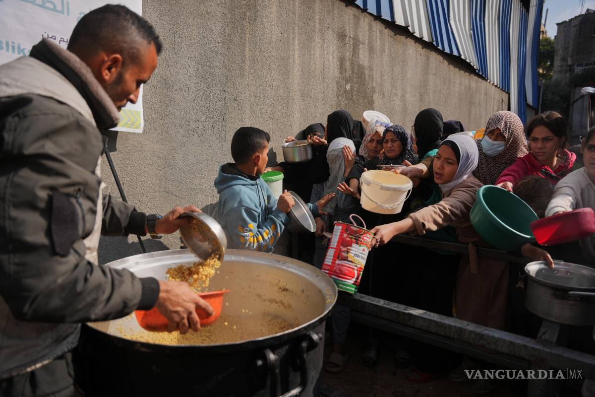 $!Mujeres palestinas luchan por recibir alimentos donados en un comedor comunitario en Nuseirat, en el centro de la Franja de Gaza.
