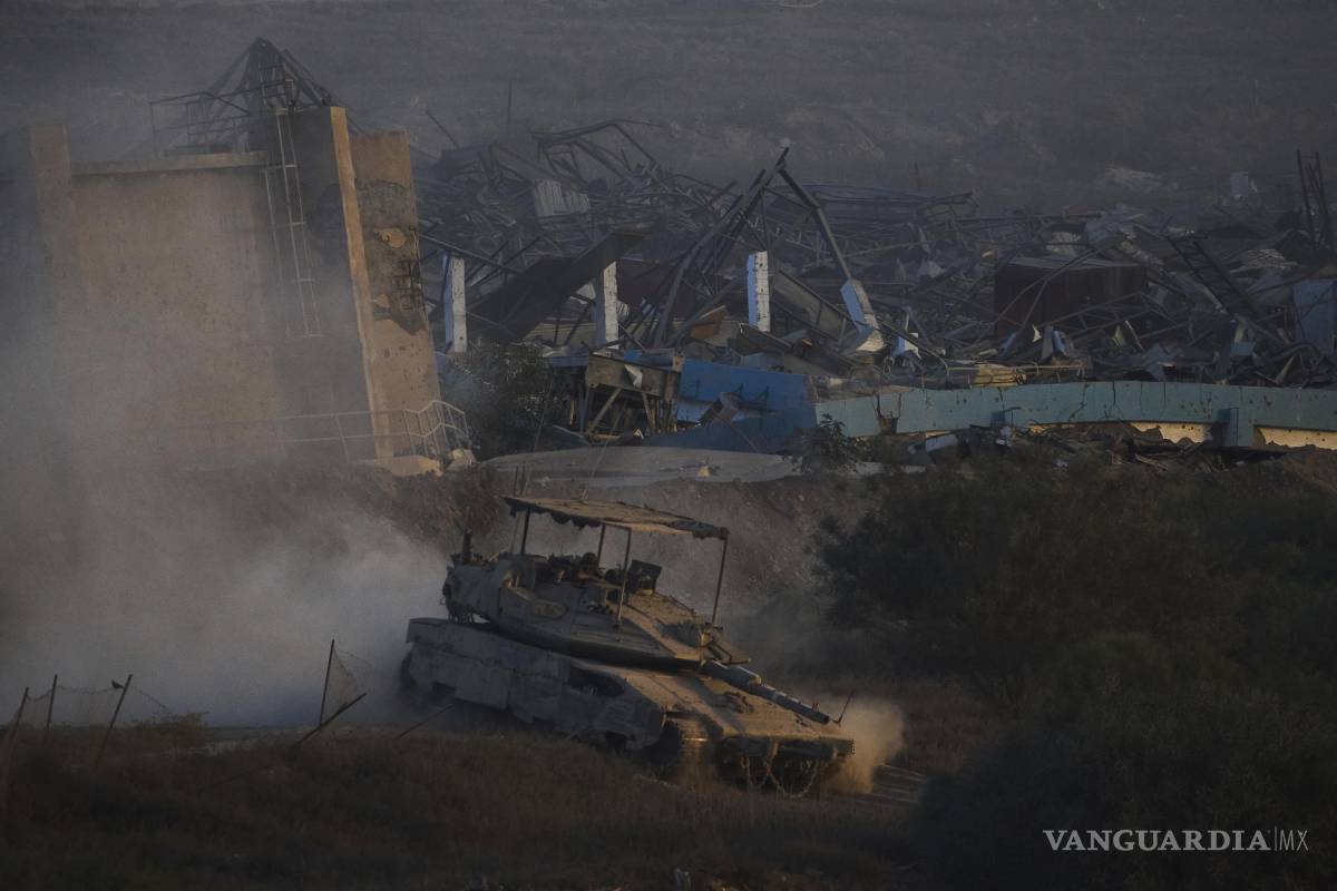 $!Soldados israelíes conducen un tanque dentro de la Franja de Gaza visto desde el sur de Israel.