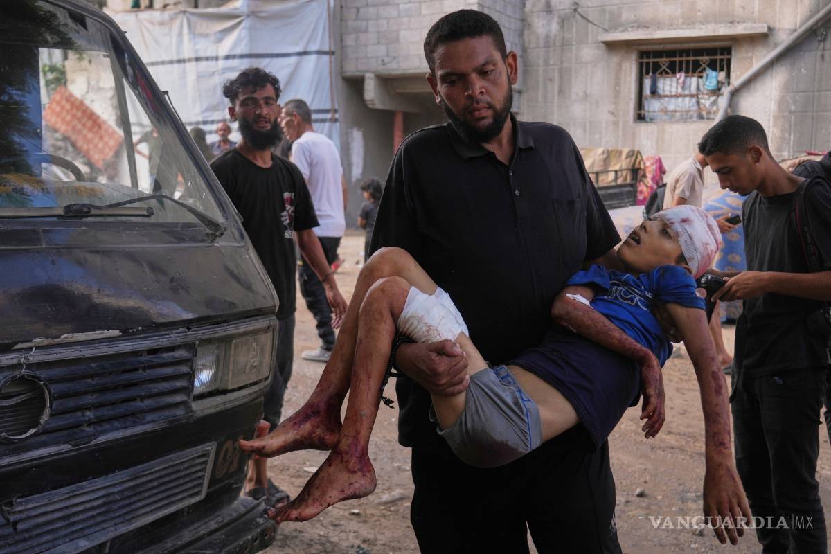 $!Un hombre lleva el cuerpo de Abdul Rahman, de 12 años, un niño palestino que murió en un ataque militar israelí en la Franja de Gaza.