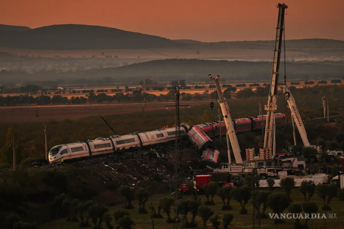 $!Grúas levantan vagones de tren mientras rescatistas buscan víctimas de una colisión entre dos trenes en Urda, España, el jueves 29 de octubre de 2026.