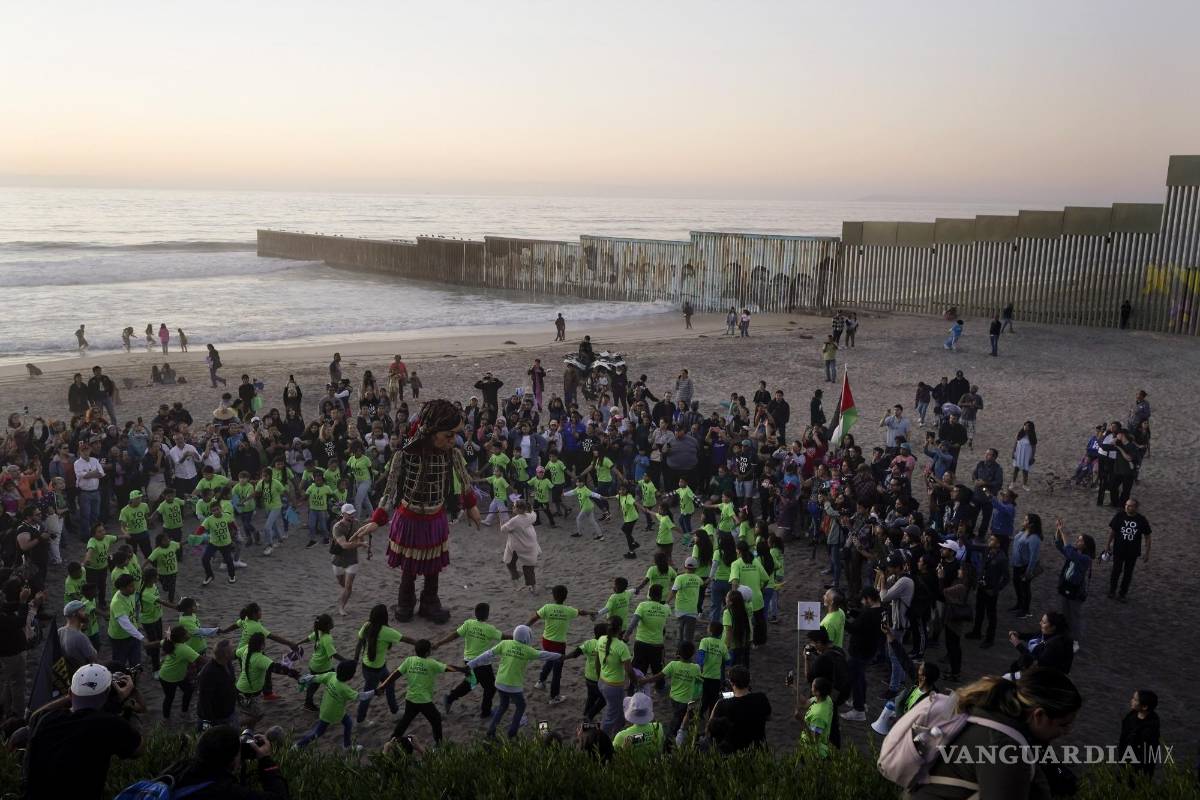 $!La pequeña Amal baila con niños en la playa donde el muro fronterizo que divide a Estados Unidos y México en Tijuana.