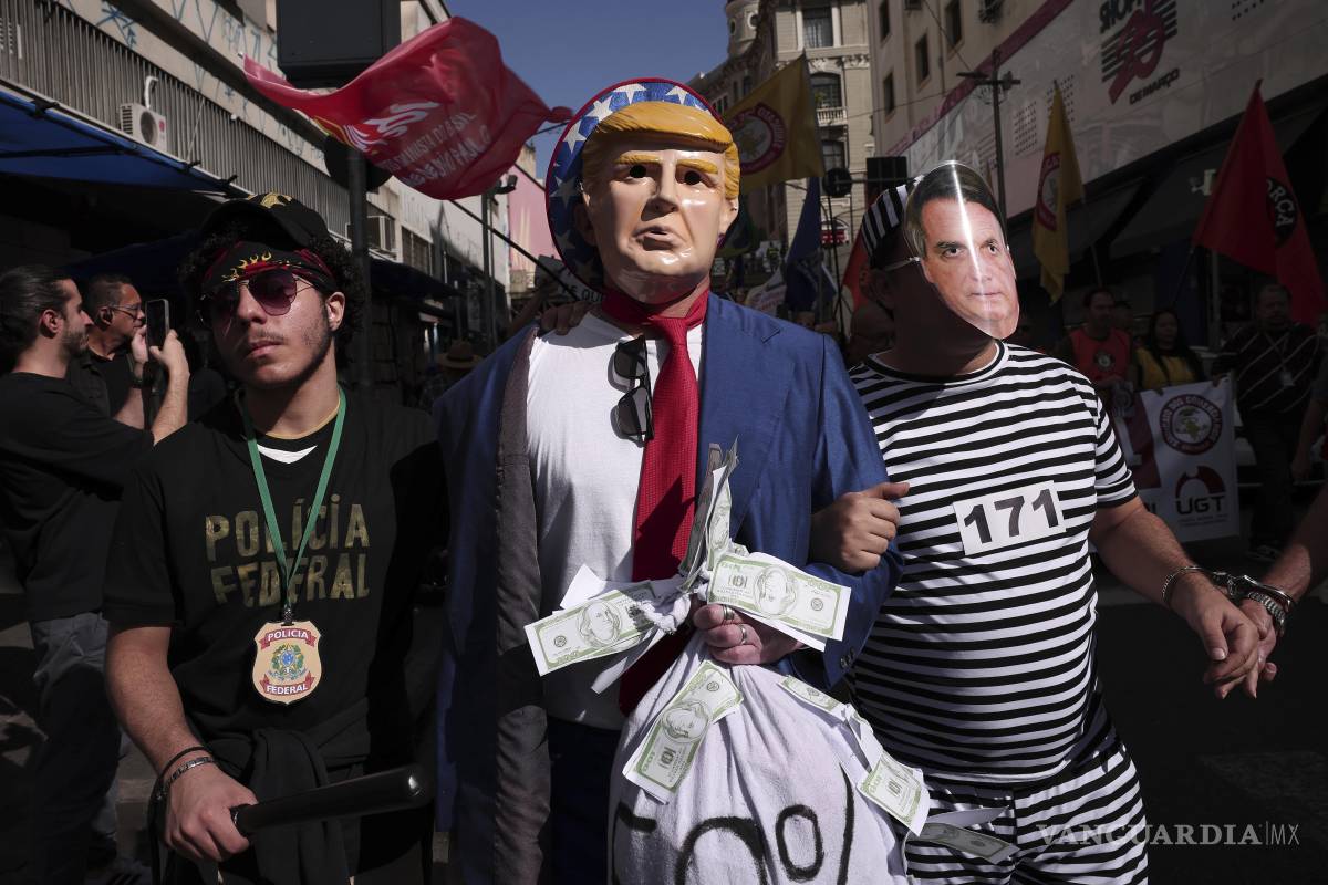 $!Manifestantes vestidos de policías escoltan a Donald Trump y a Jair Bolsonaro para protestar contra el anuncio de Trump de imponer aranceles del 50%.