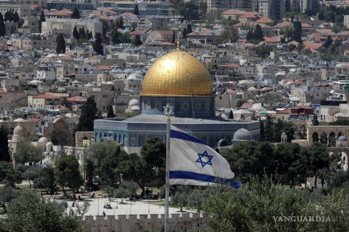 $!La bandera israelí ondea frente a la Ciudad Vieja de Jerusalén y la Cúpula de la Roca, vista desde el Monte de los Olivos en Jerusalén.