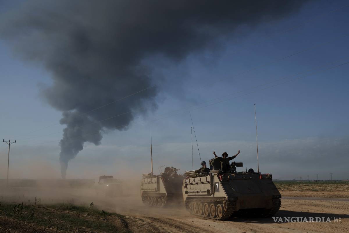 $!Soldados israelíes cerca de la frontera entre Israel y Gaza, con una humareda al fondo, en la Franja de Gaza, vista desde el sur de Israel, el 21 de enero de 2025.