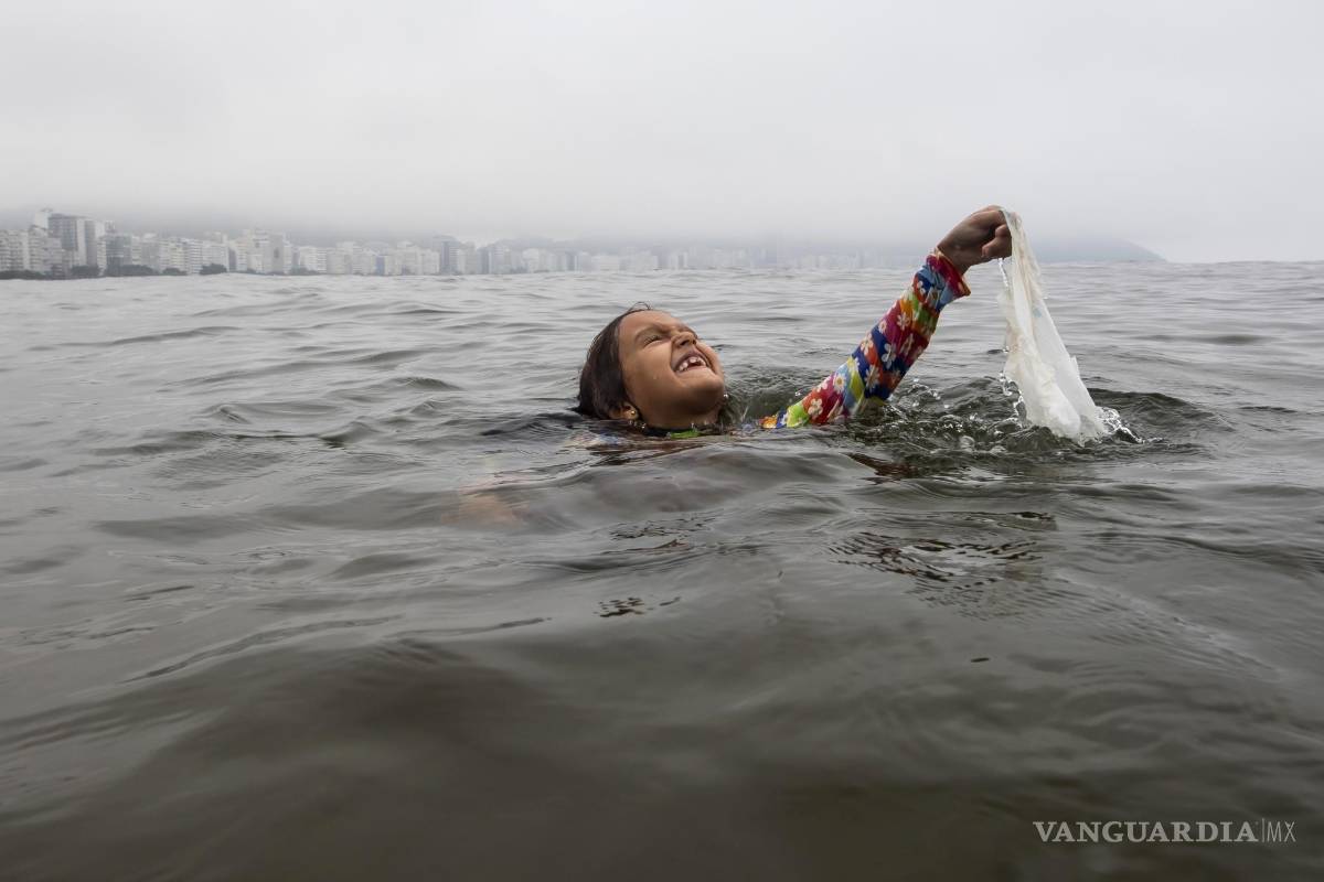 $!Nina Gomes recupera una bolsa de plástico desechada de las aguas del océano, cerca de la playa de Copacabana en Río de Janeiro, Brasil.