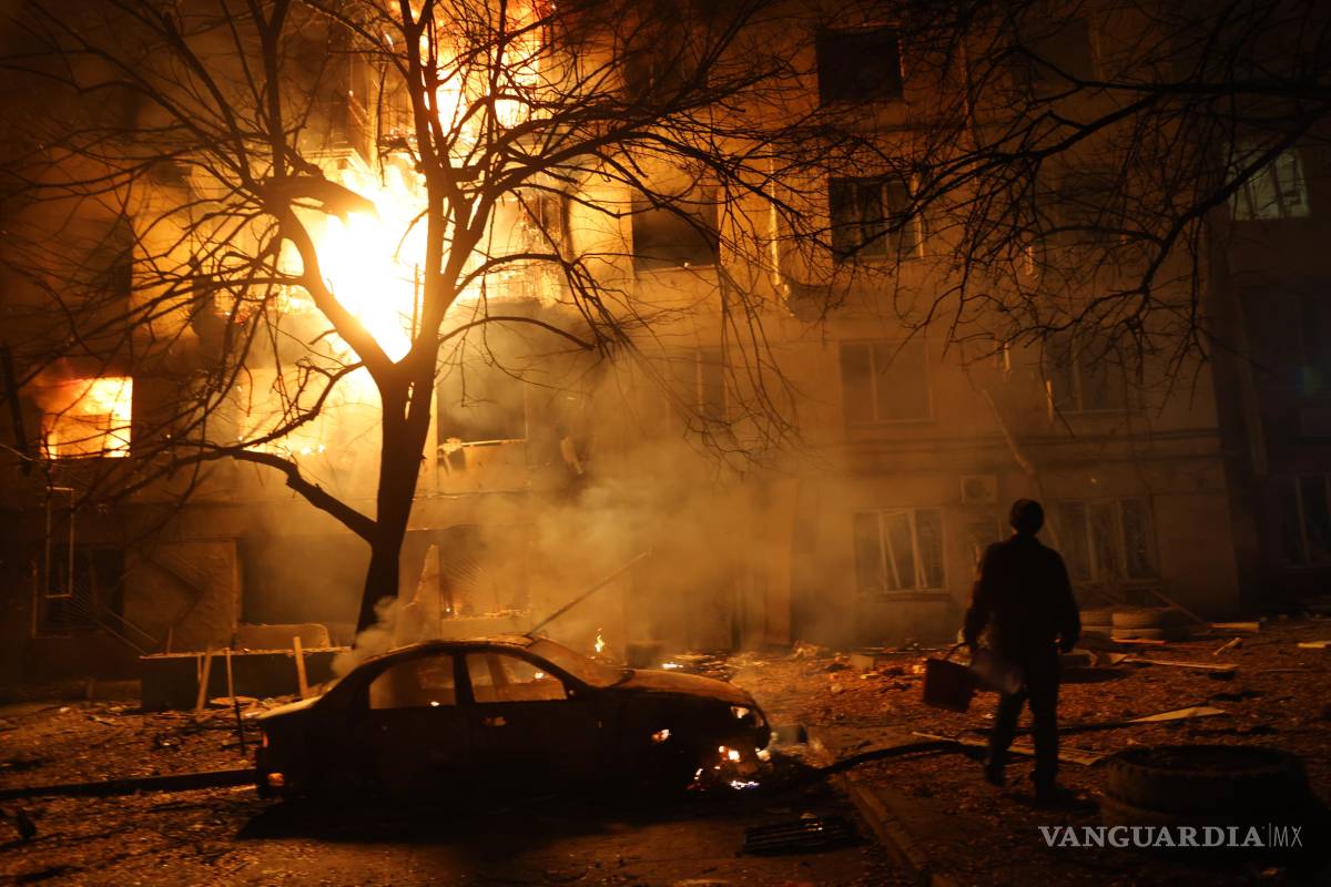 $!Un hombre camina frente a un edificio residencial en llamas tras un ataque ruso en Zaporiyia, Ucrania.