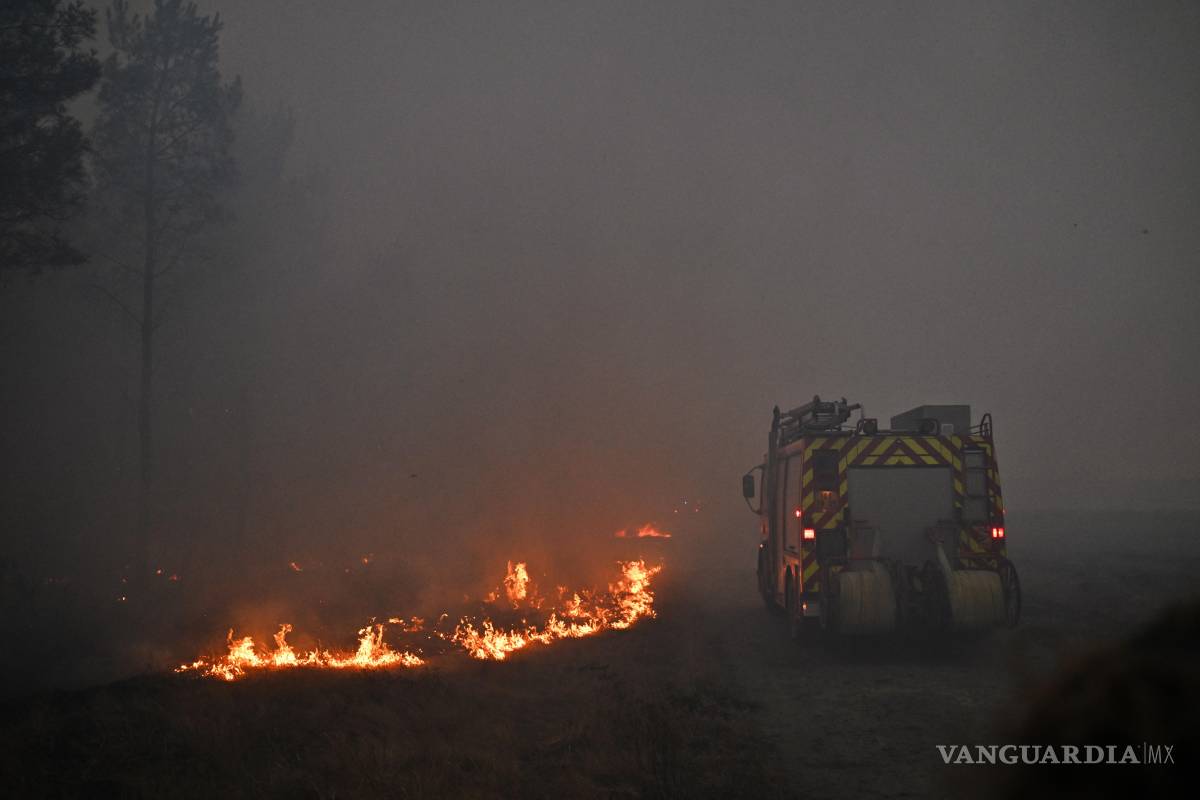 $!Un camión de bomberos avanza entre el humo de un incendio cerca de Marcheprime, a las afueras de Burdeos, Francia, el domingo 26 de julio de 2026.
