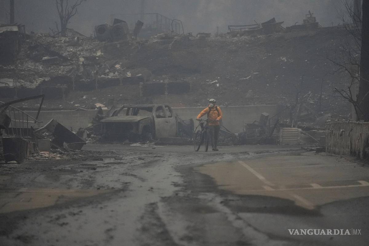 $!Una persona anda en bicicleta por una zona quemada mientras el incendio de Palisades arrasa un vecindario en el vecindario Pacific Palisades de Los Ángeles.
