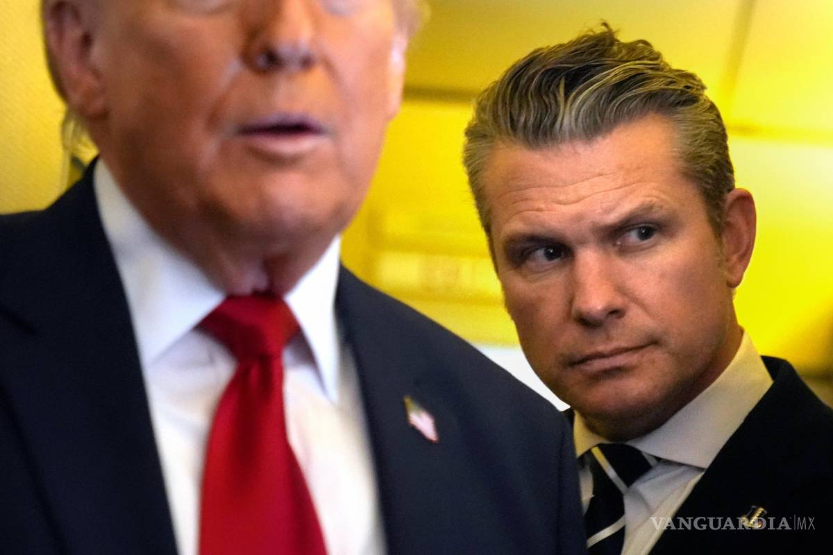 $!El secretario de Defensa, Pete Hegseth, escucha mientras el presidente Donald Trump habla con periodistas en el Air Force One.