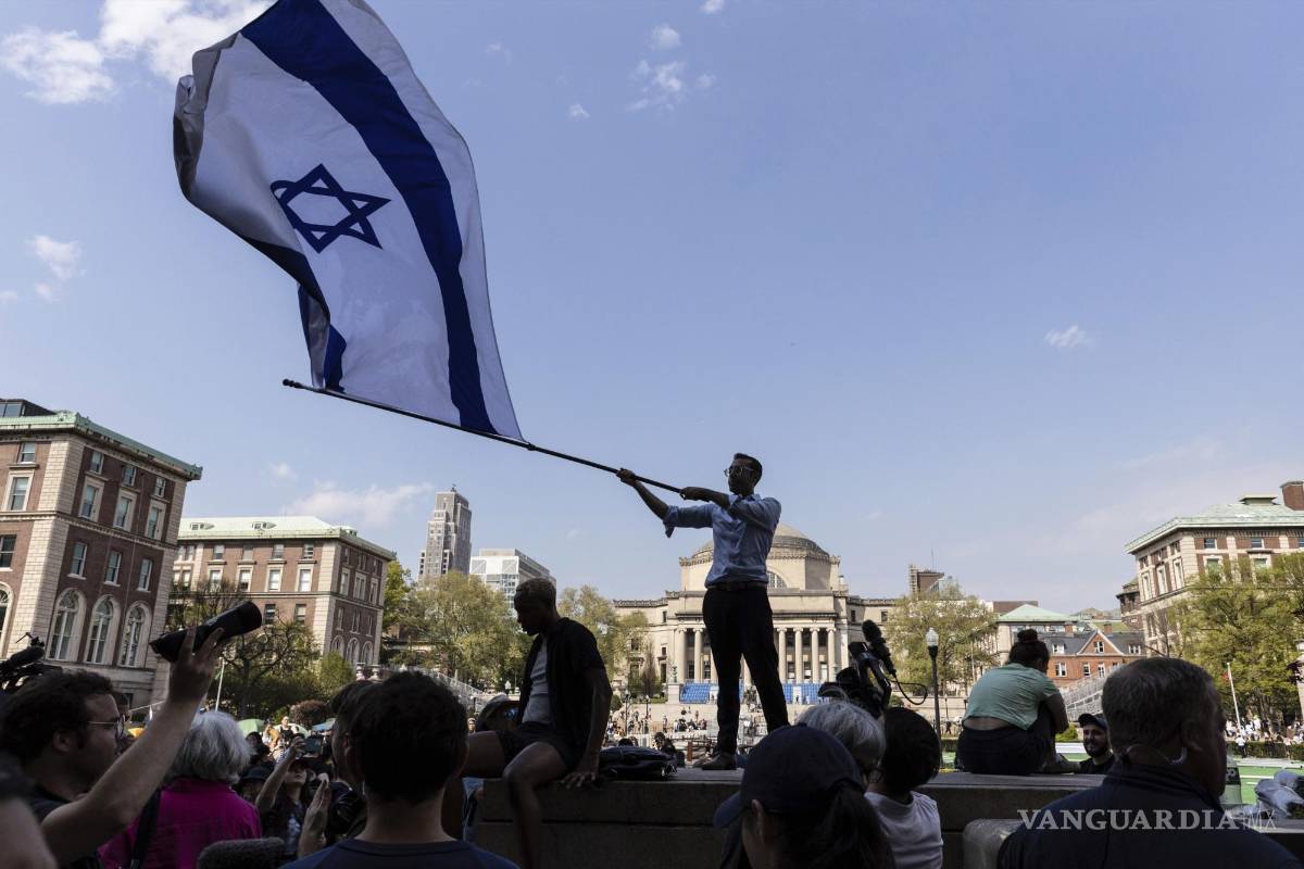 $!David Lederer, estudiante de segundo año de Columbia, ondea una gran bandera de Israel frente al campamento de protesta estudiantil en la Universidad de Columbia