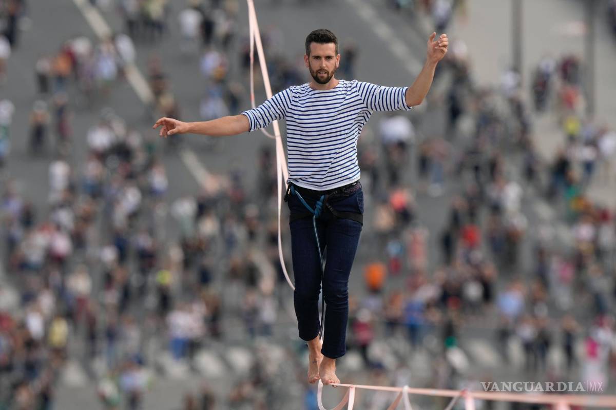 $!El francés Nathan Paulin actúa por segunda vez en un slackline de 70 metros de altura entre la Torre Eiffel y el Teatro Chaillot al otro lado del río Sena, en París. AP/Francois Mori