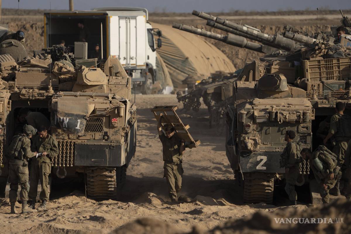 $!Soldados israelíes trabajan en sus vehículos blindados estacionados en una zona de preparación cerca de la frontera entre Israel y Gaza.