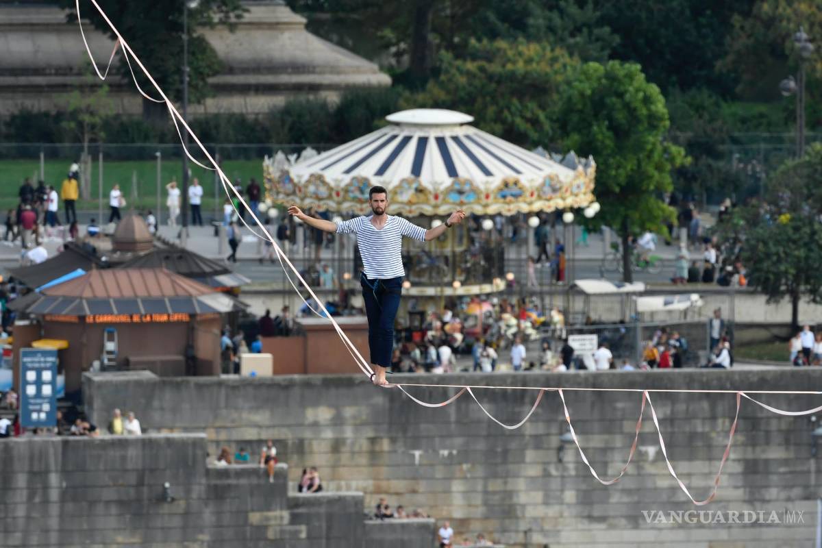 $!El acróbata francés Nathan Paulin camina por una línea alta desde la Torre Eiffel a través del río Sena, como parte de los eventos en Francia para los Días del Patrimonio Nacional en París. AP/Alain Jocard
