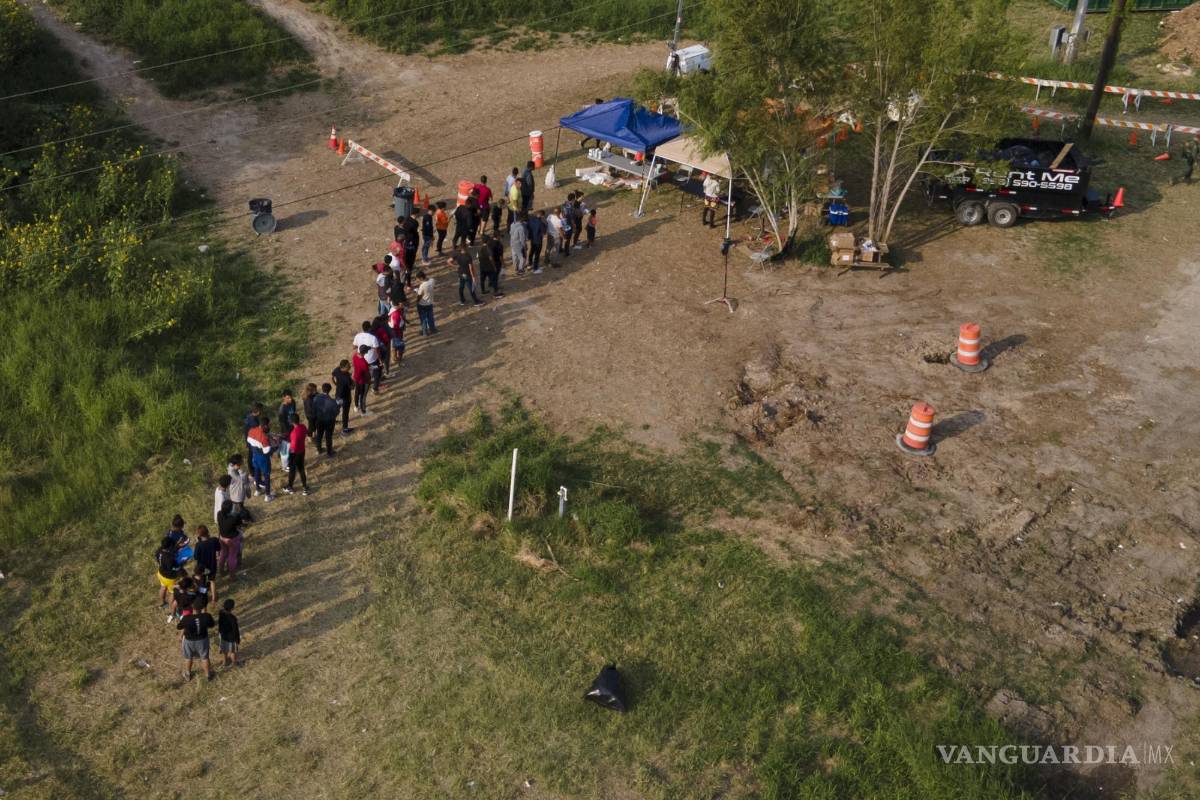 $!Los migrantes son procesados en un campo después de cruzar el Río Grande en la frontera entre Texas y México, el jueves 11 de mayo de 2023, en Brownsville, Texas.