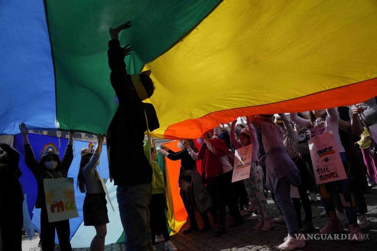 $!Niños juegan bajo una enorme bandera de la paz del arco iris durante la oración del mediodía del Ángelus del Papa Francisco en la Plaza de San Pedro en el Vaticano.