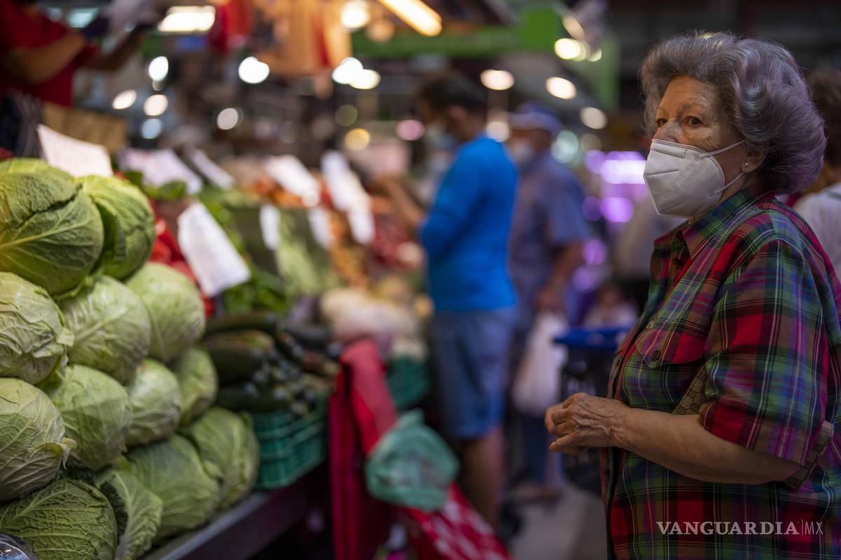 $!Un cliente con mascarilla espera para comprar verduras en el mercado de Maravillas en Madrid, España.
