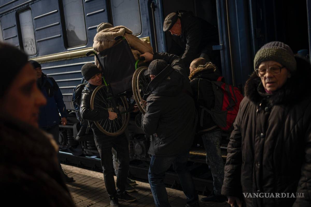 $!Ucranianos que huyeron de la sitiada ciudad de Mariúpol y otros pasajeros procedentes de Zaporiyia llegan a Leópolis, en Ucrania, el 20 de marzo de 2022.