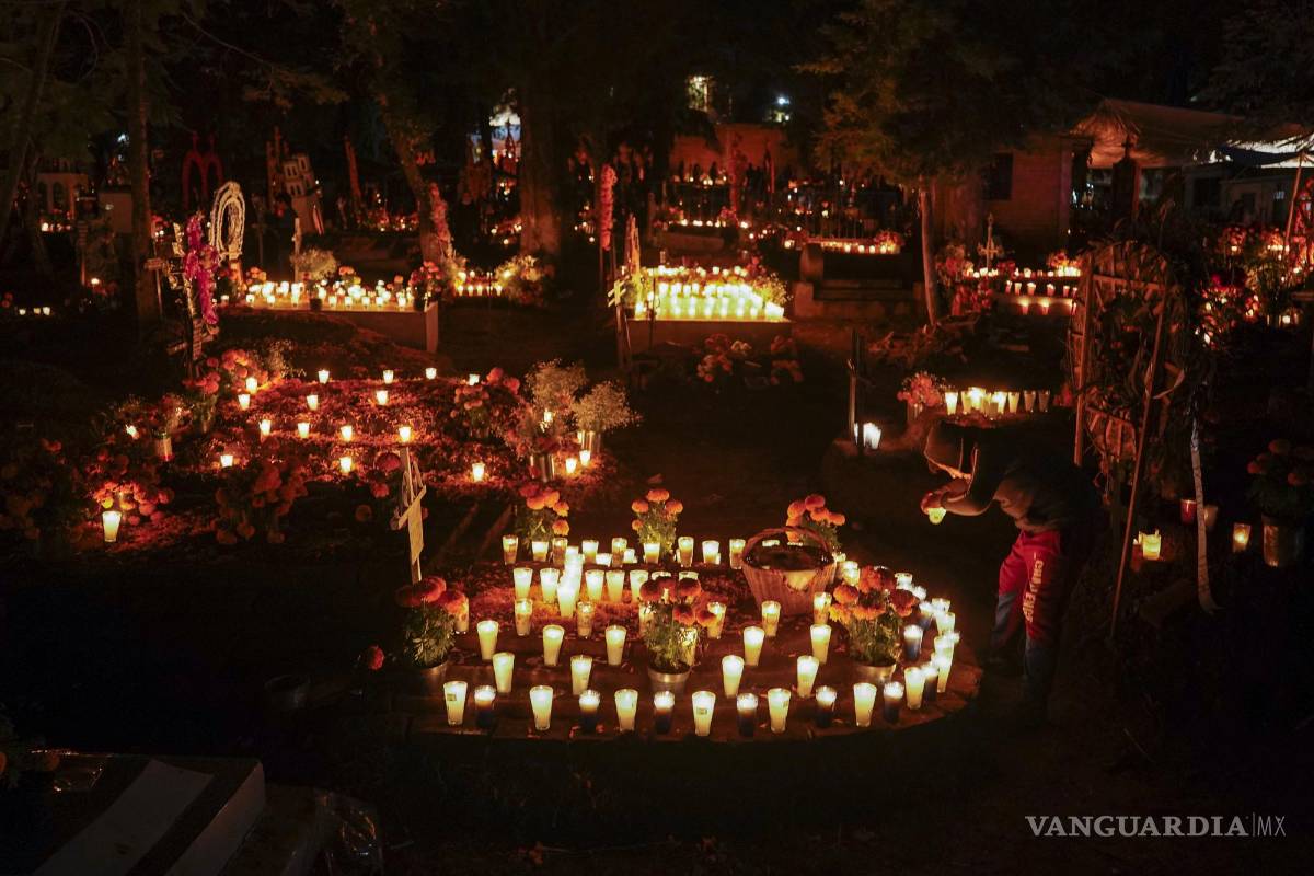 $!Familiares hacen vigilia junto a las tumbas de sus seres queridos durante las festividades por el Día de Muertos en el cementerio de Tzintzuntzan, en el estado de Michoacán, México. AP Foto/Eduardo Verdugo