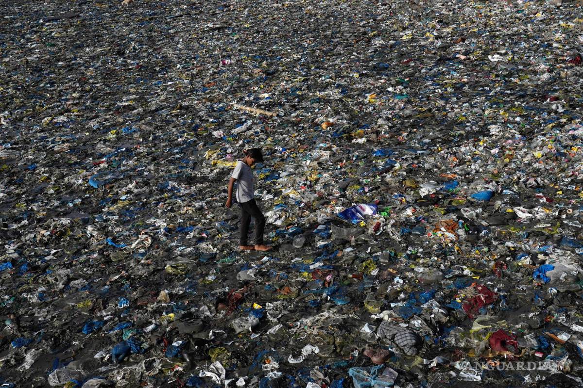 $!Un niño camina sobre los desechos plásticos en la playa de Badhwar Park, en la costa del Mar Arábigo, en el Día Mundial del Medio Ambiente en Mumbai, India.