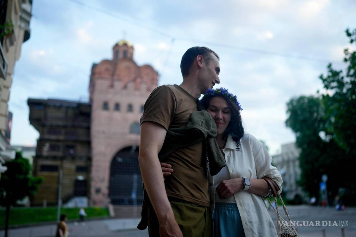 $!Los cómicos de stand-up Serhiy Lipko y Anastasia Zukhvala se abrazan el día de su boda en Kiev, Ucrania.