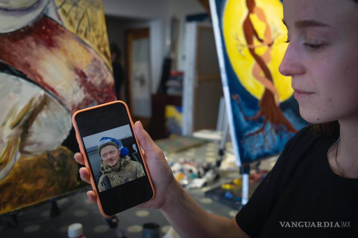 $!Olesia Skalska muestra una foto de su esposo Roman Skalskyi, quien murió en batalla con las tropas rusas, en un estudio en Kiev, Ucrania.