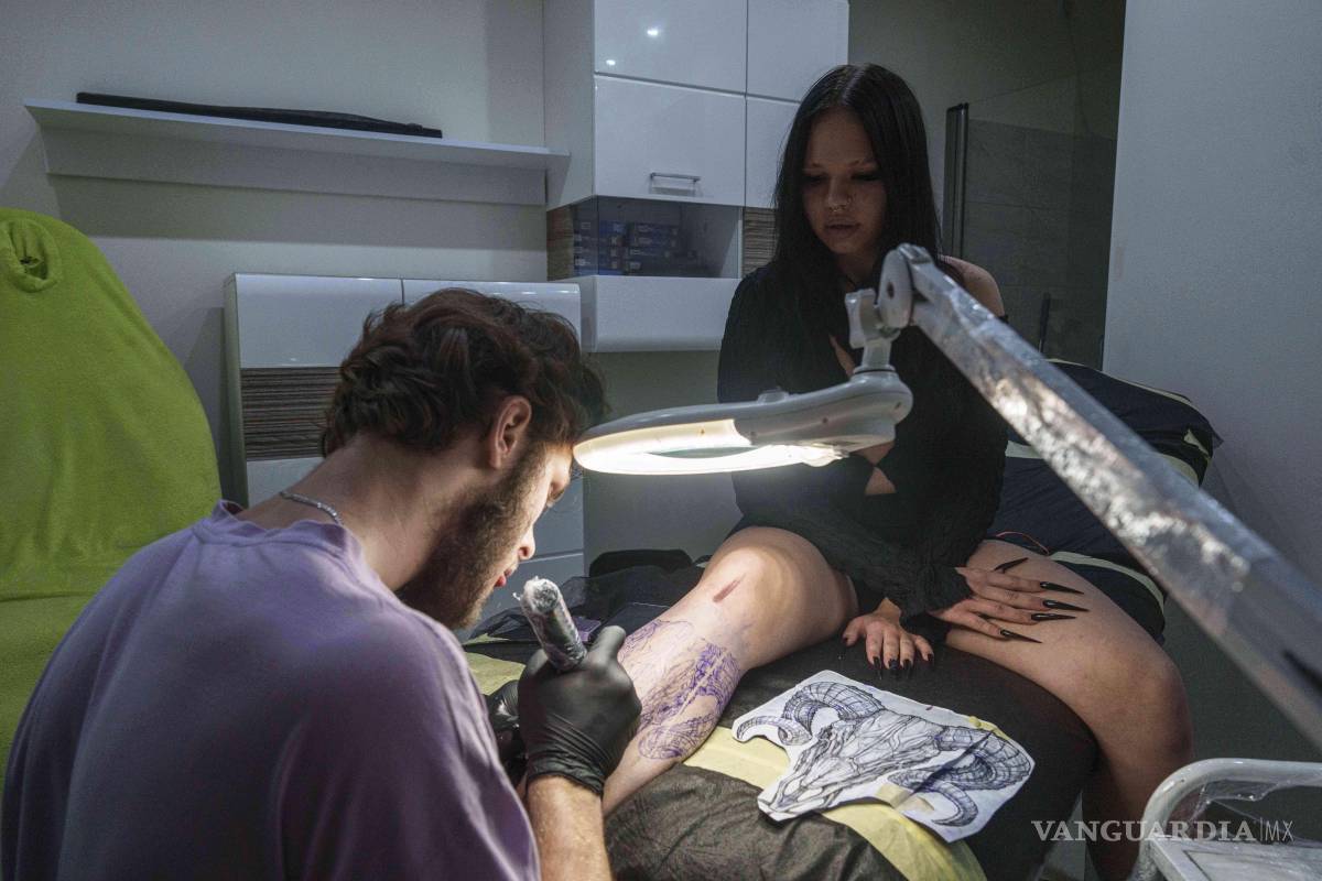 $!Daria Horlova, de 18 años, se sienta mientras su novio le hace un tatuaje en Kramatorsk, Ucrania.