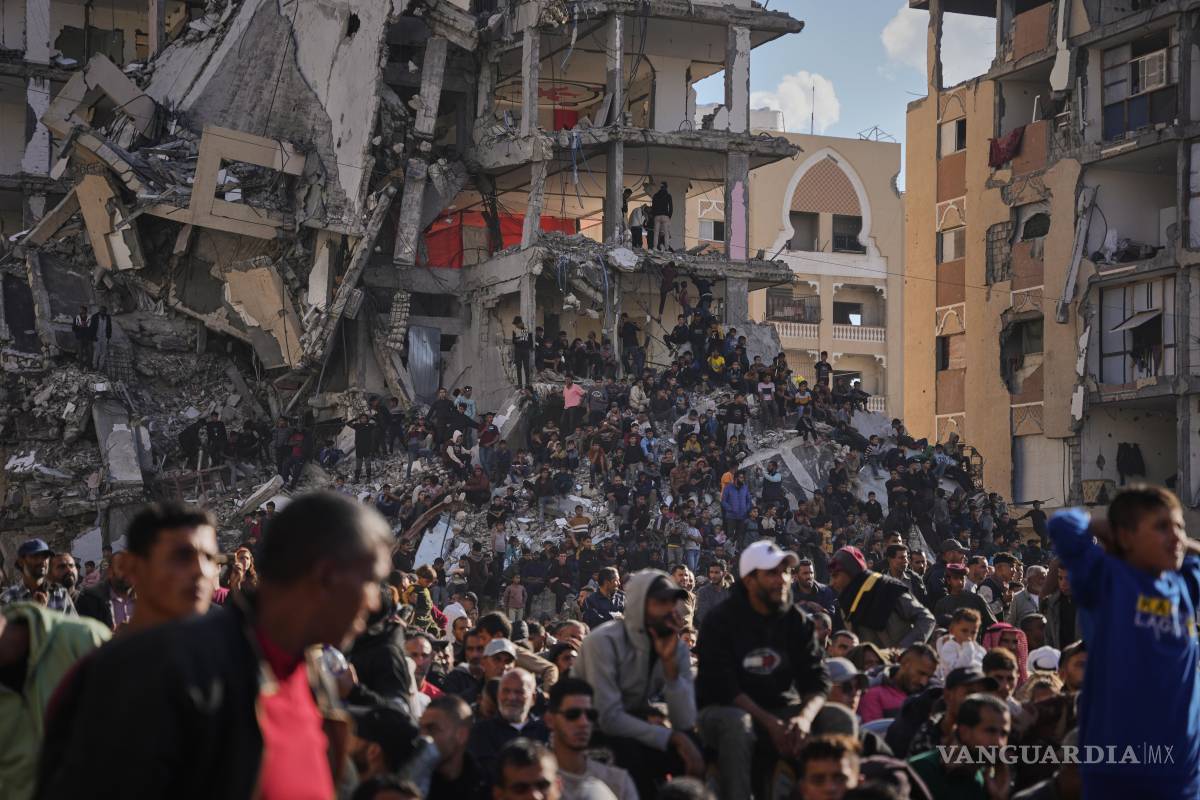 $!Palestinos de pie sobre los escombros observan y celebran una boda multitudinaria en Khan Younis, Franja de Gaza.