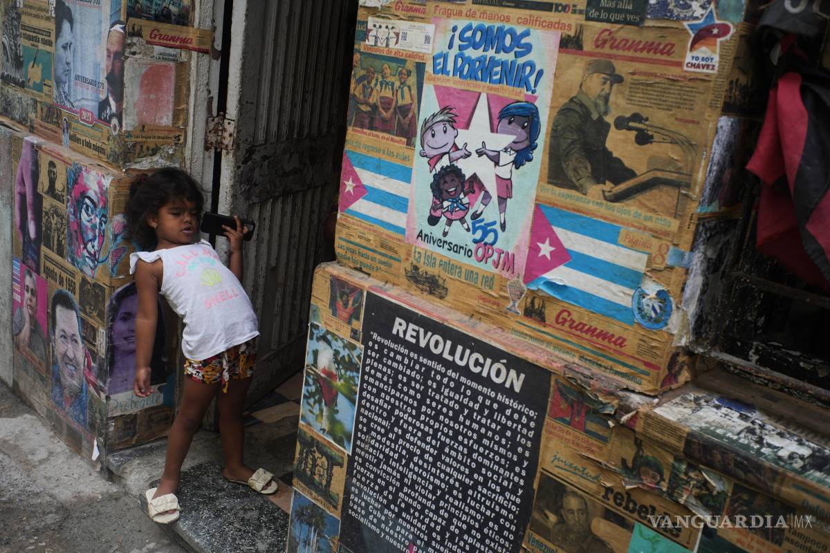 $!Una niña juega en la entrada del edificio donde se encuentra una instalación artística relacionada con la Revolución Cubana, durante un apagón en La Habana.