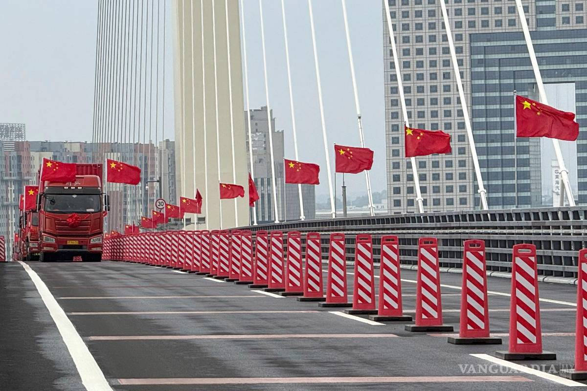 $!Camiones con banderas chinas en la ceremonia de inauguración del nuevo puente sobre el río Yalu, entre China y Corea del Norte, en la frontera entre ambos países.