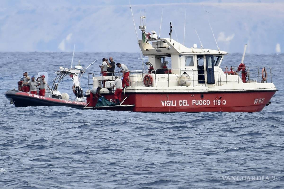 $!Buzos de los bomberos italianos llevan hasta un barco la bolsa con los restos mortales de una de las víctimas del naufragio del yate Bayesian en Porticello.