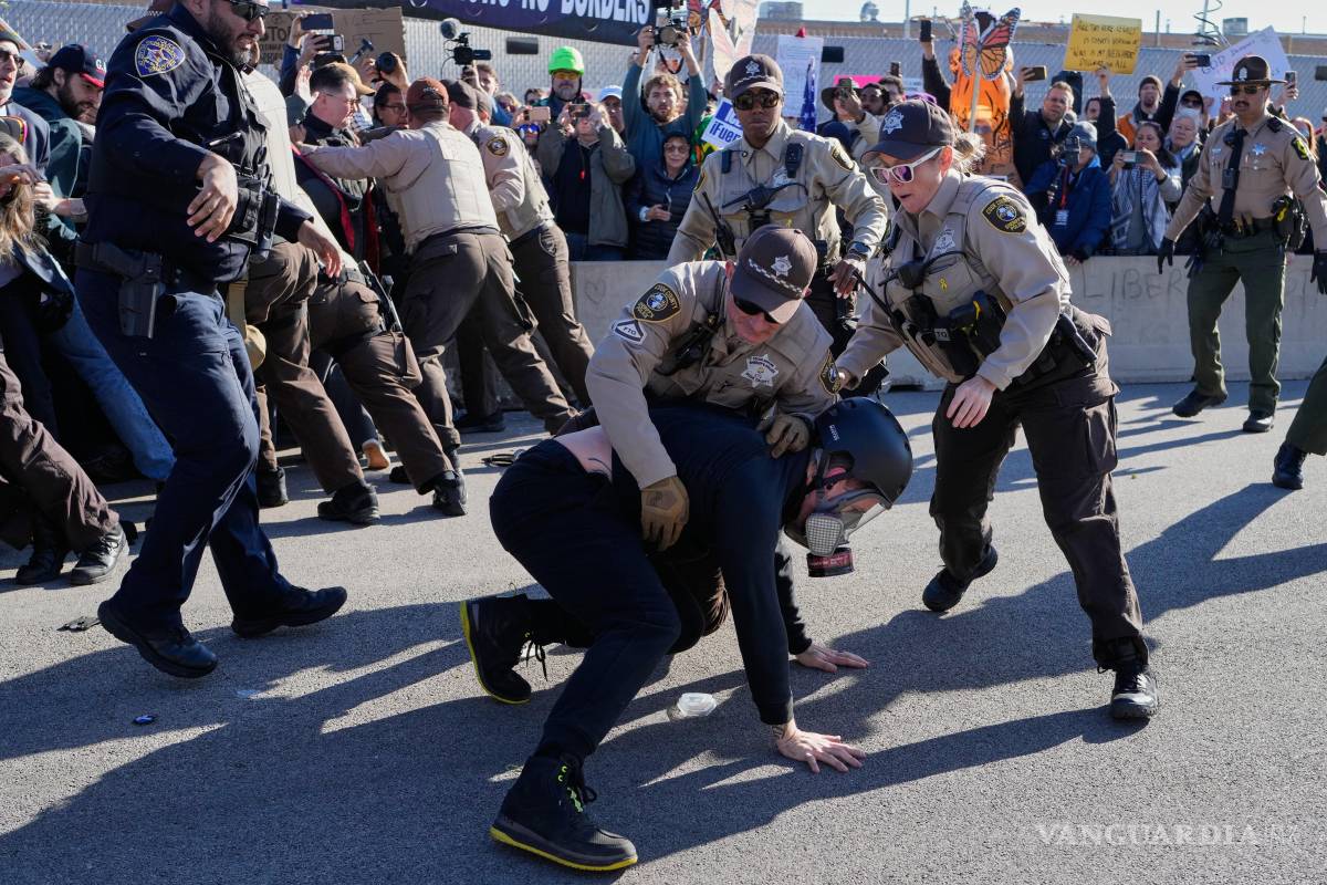$!Agentes de policía del condado de Cook detienen a un manifestante fuera de una instalación de procesamiento del ICE en Broadview, Illinois.