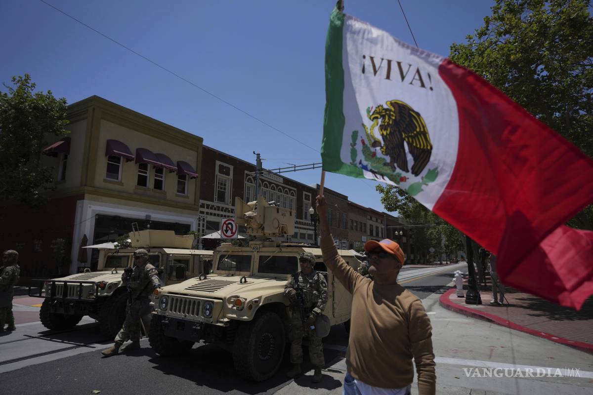 $!Un manifestante con una bandera de México junto a elementos de la Guardia Nacional de California. En Truth Social, Trump sugirió que los manifestantes eran “¡insurrectos a sueldo!”.