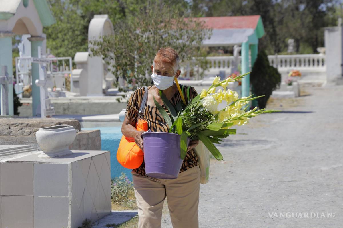 $!Mujer cargando flores en el panteón.