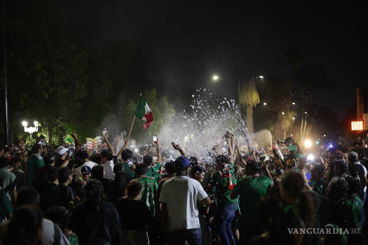$!Entre espuma, banderas y consignas, los aficionados celebraron el triunfo de México sobre Ecuador, mientras elementos de seguridad resguardaban la zona para mantener el orden durante la concentración.