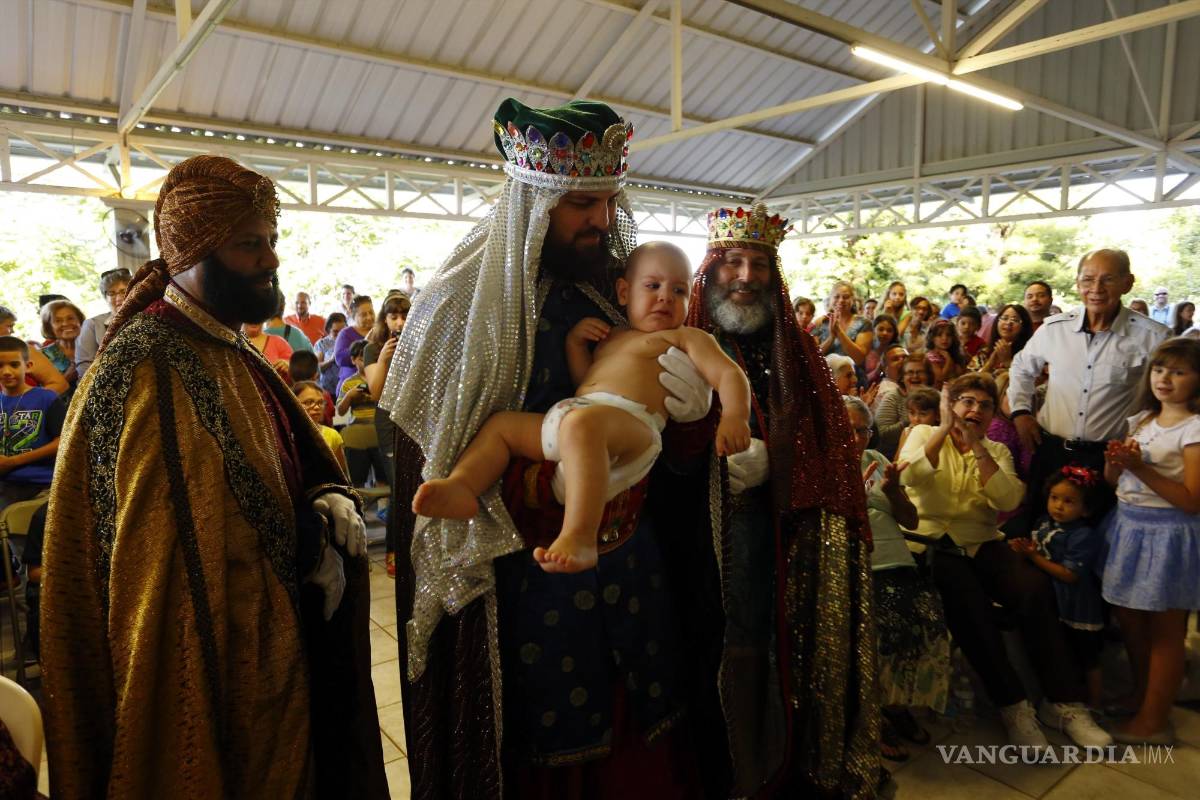$!Los tres Reyes Magos levantan a Wilfredo Mateo Díaz, quien interpreta al niño Jesús en el Centro Capuchino de Trujillo Alto en San Juan, Puerto Rico. EFE/Thais Llorca