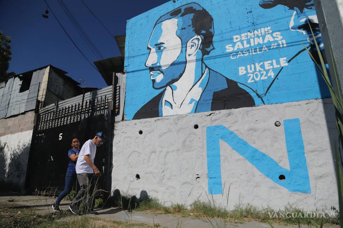 $!Una mujer con un anciano junto a un mural de la campaña Nuevas Ideas que promociona al presidente Nayib Bukele, quien se postula para la reelección.