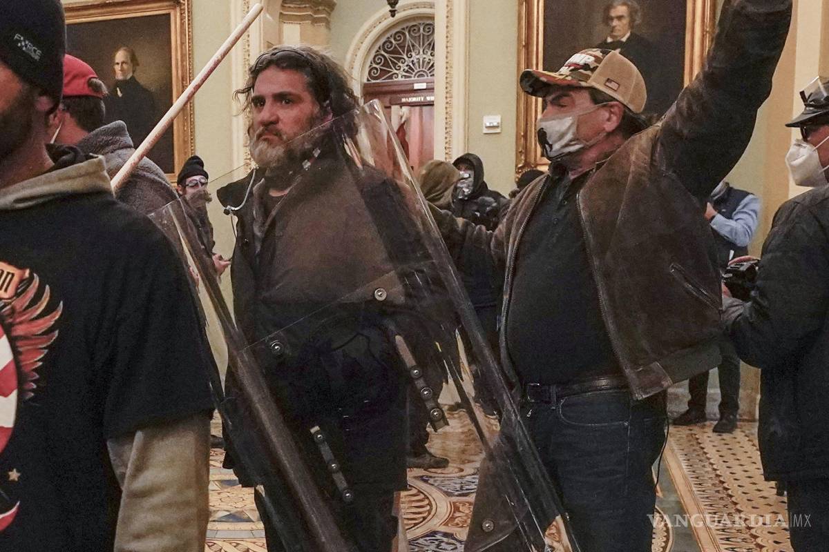$!Dominic Pezzola, en el centro con escudo policial, son confrontados por agentes de la Policía del Capitolio el miércoles 6 de enero de 2021, en Washington.
