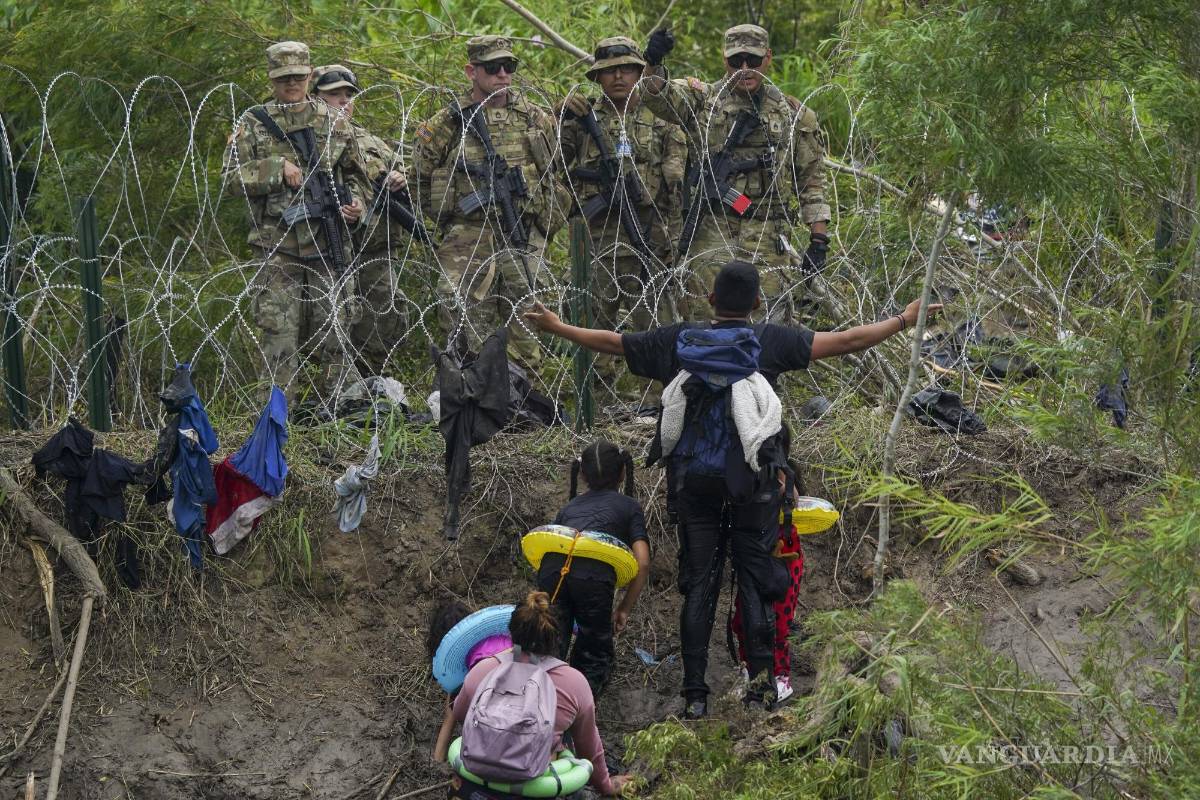 $!Un migrante habla con efectivos de la Guardia Nacional de Texas en la orilla del Río Bravo, vistos desde Matamoros, México, el 11 de mayo de 2023.