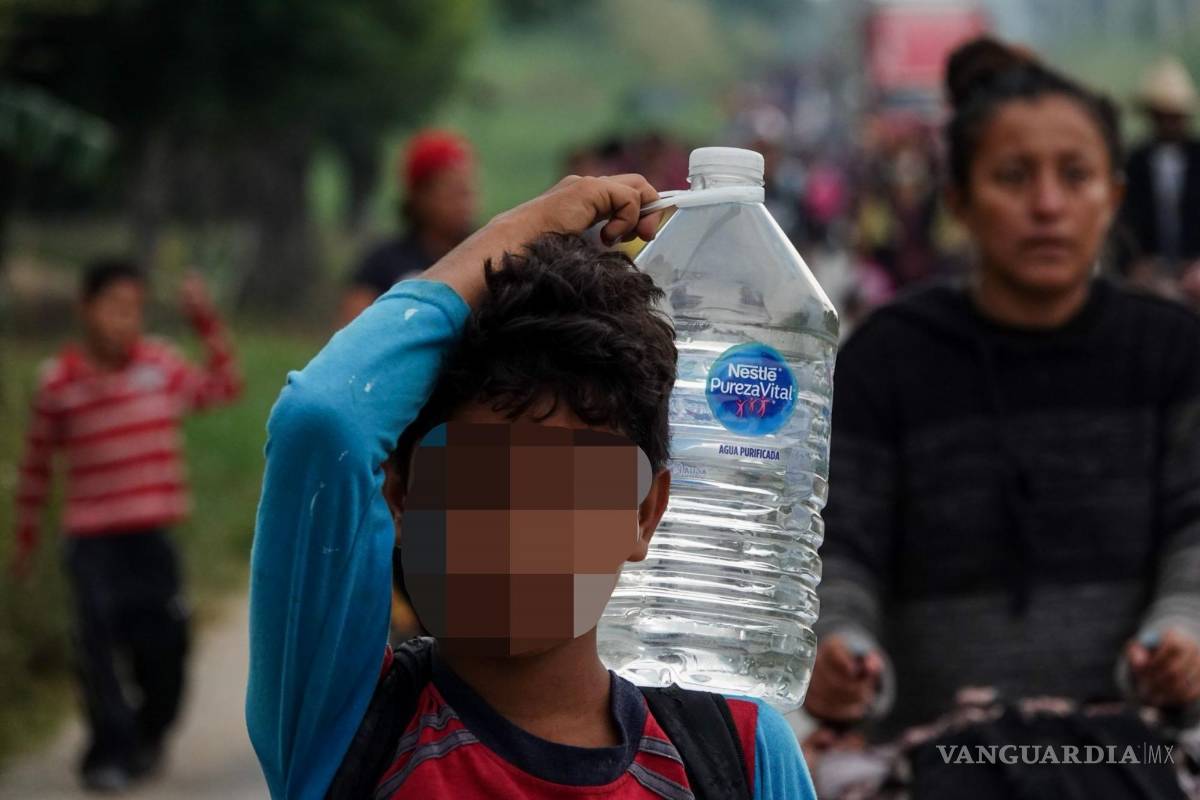 $!Un niño migrante carga un garrafón con agua a su salida del poblado de Nuevo Morelos, Veracruz para continuar su recorrido por el estado.